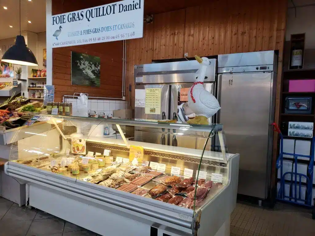 Boucherie artisanale de foie gras : pancarte "FOIE GRAS QUILLOT Daniel" et vitrine réfrigérée remplie de confits et produits carnés.