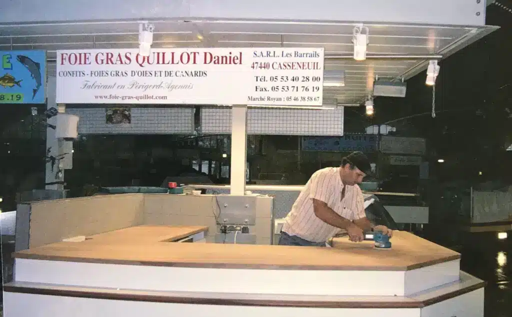 Foie Gras Quillot Daniel : Installation Marché Homme ponçant un comptoir de marché pour Foie Gras Quillot Daniel, fabricant en Périgord-Agenais à Casseneuil.